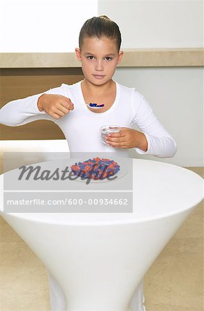 Portrait de jeune fille assise à Table repas de pilules