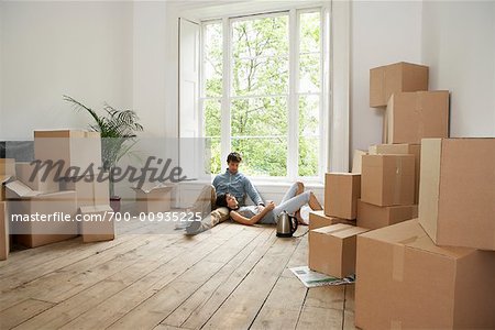 Couple détente dans la nouvelle maison le jour du déménagement