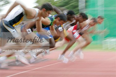 Male Runners Leaping Off Starting Blocks