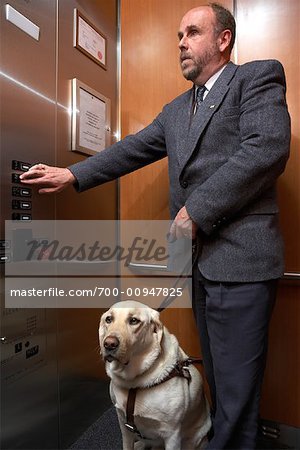 Homme aveugle avec chien-Guide sur l'ascenseur