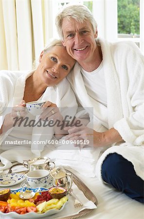 Mature Couple Eating Breakfast In Bed