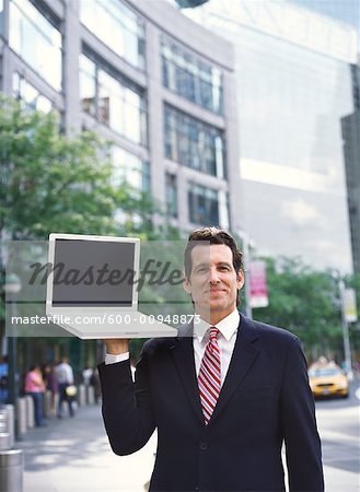 Businessman Holding Laptop Computer in City
