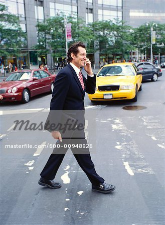 Homme d'affaires avec téléphone cellulaire croisement rue