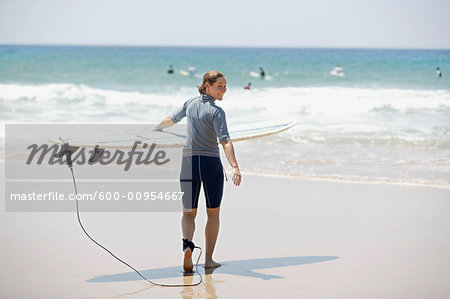 Woman Walking Toward Water with Surfboard, Noosa Beach, Australia