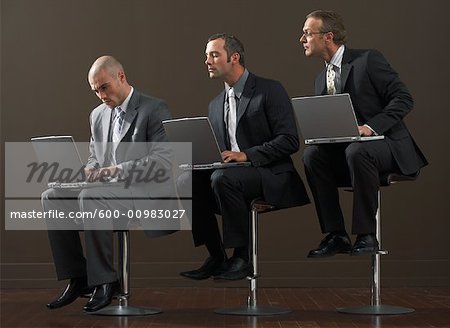 Trois hommes d'affaires à l'aide d'ordinateurs portables