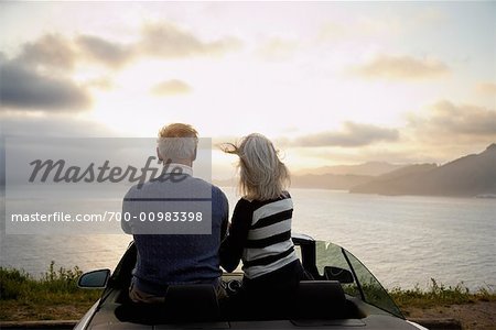 Couple regarder le coucher de soleil depuis Convertible, San Francisco, Californie, USA