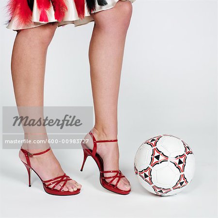 Femme en talons hauts sur le point de botter le ballon de Soccer