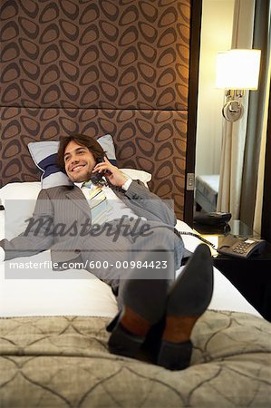 Businessman Using Telephone in Hotel Room