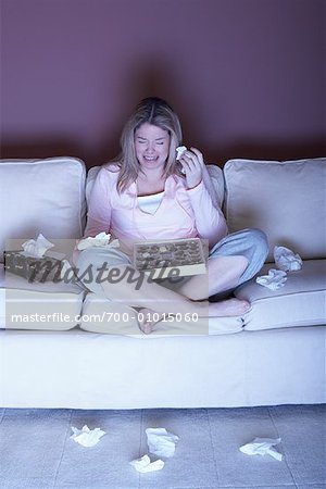 Femme qui pleure au chocolat sur canapé