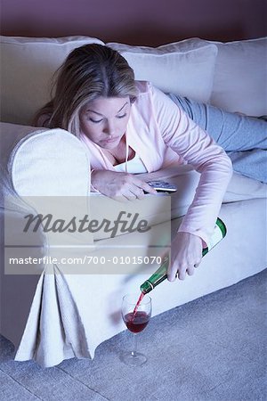 Woman on Sofa with Remote Control and Wine