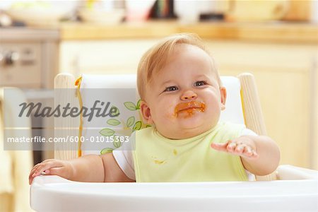 Baby with Messy Face in High Chair