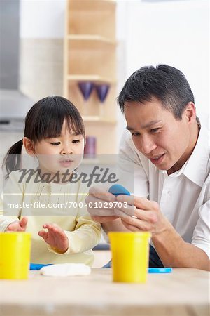 Vater und Tochter spielen mit Knetmasse