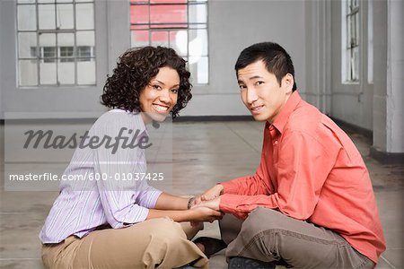 Couple Sitting on Floor Holding Hands