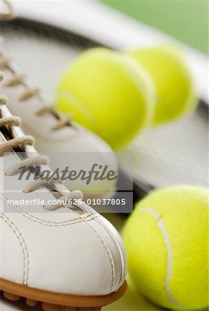 Close-up of a tennis shoe with tennis balls and a racket