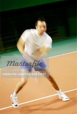 Mid adult man playing tennis