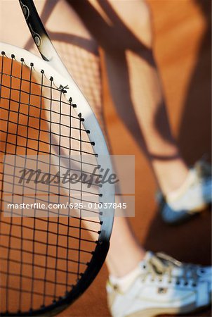 Low section view of a person with a tennis racket