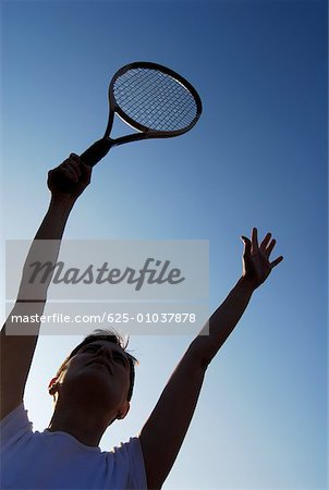 Vue d'angle faible d'une femme adulte mid tenant une raquette de tennis