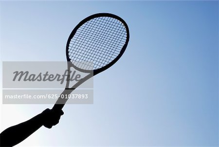 Low angle view of a person's hand holding a tennis racket