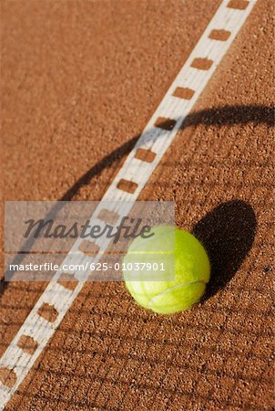 Ombre d'une raquette de tennis sur une balle de tennis