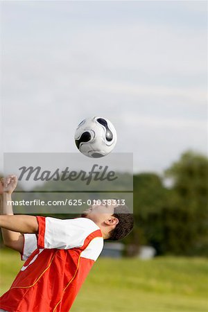 Close-up of a soccer player heading a soccer ball