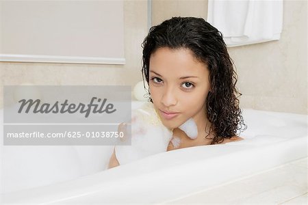 Portrait d'une jeune adolescente, frottant son dos dans la baignoire