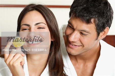 Close-up of a young woman holding a cupcake with a mid adult man looking at her