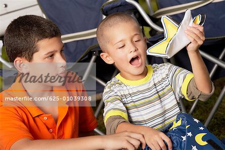 Close-up of a boy looking at his brother holding a star