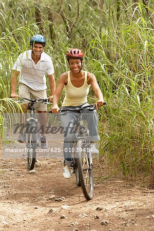 Portrait of a mid adult man and a young woman riding bicycles