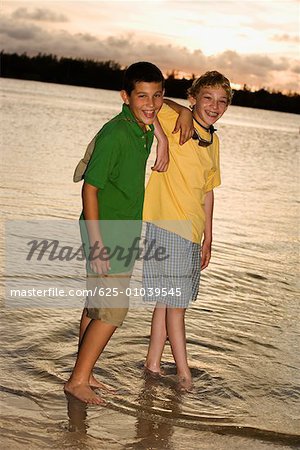 Portrait de deux garçons, debout sur la plage