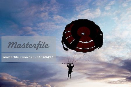 Silhouette of a person parasailing at sunset, Bahamas