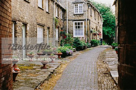 Vue latérale des maisons à côté d'une chaussée pavée, Burford, Angleterre