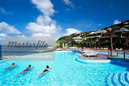 Three people relaxing in a swimming pool of a resort near a seashore, St. Bant's