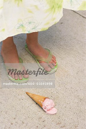 Gros plan des pieds et des cornet de crème glacée sur le sol de la jeune fille