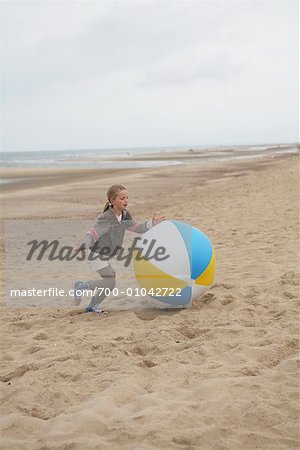 Fille jouant avec gros ballon de plage