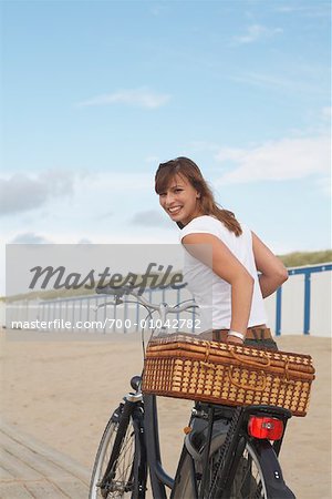 Porträt Frau mit Fahrrad am Strand