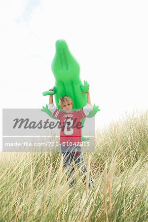 Boy Carrying Inflatable Alligator