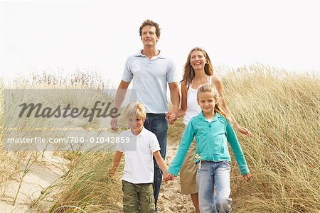 Portrait of Family Walking Through Tall Grass on Beach