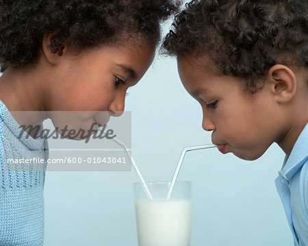 Children Sharing a Glass of Milk