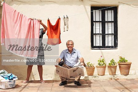 Couple sur le Patio avec des journaux et une laverie