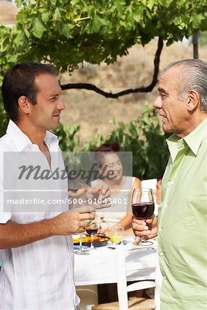 Vater und Sohn sprechen, mit anderen Mitgliedern der Familie im Hintergrund