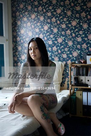 Portrait of Tattooed Woman in Bedroom