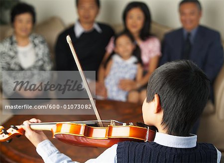 Family Watching Boy Play Violin