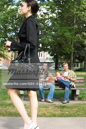 Frau zu Fuß vorbei an Männer mit Babys im Park