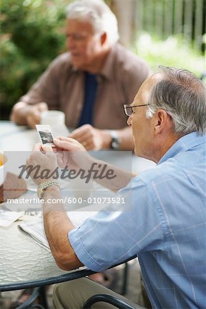 Männer sitzen im freien Blick auf Fotos