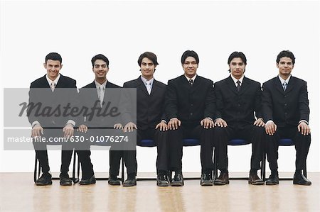 Portrait of a group of young men sitting on chairs