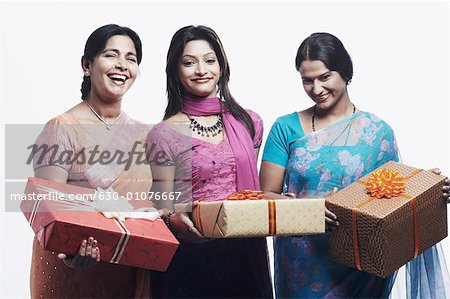 Porträt einer Mutter und ihren beiden Töchtern halten Geschenke