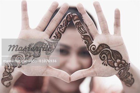 Close-up of a young woman with henna tattoo's on her hands
