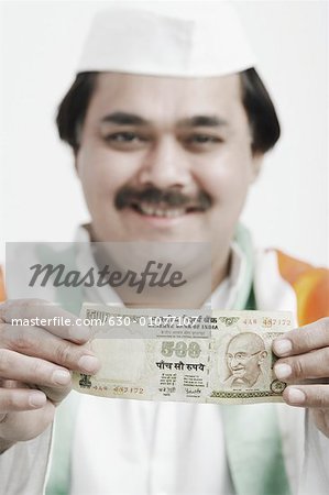 Portrait of a mature man holding Indian currency