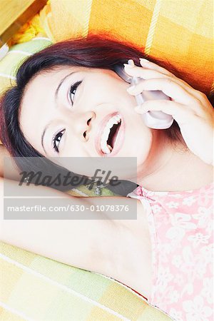 Gros plan d'une jeune femme couchée et parler sur un téléphone mobile