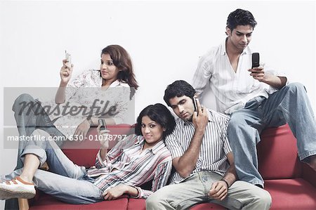 Close-up of two young couples holding mobile phones